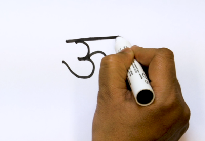 Dłoń pisząca flamastrem znak dewanagari